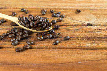 Coffee bean on wooden spoon, wooden table background