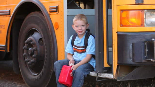 Young boy walks to front of school bus