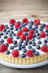Cake with blueberries and raspberries. Confectionery product.