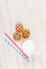 Cup of milk, cookies and drinking straws