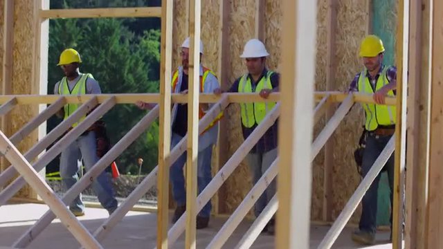 Group of construction workers staning up wall