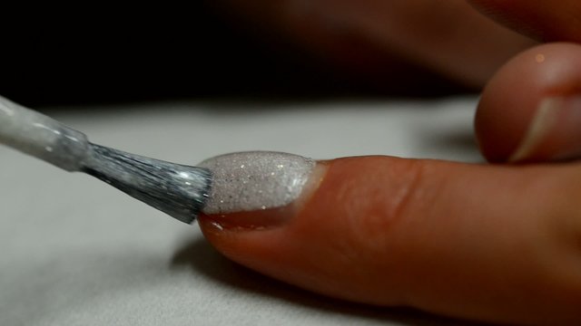 Visagistin lackiert Fingernagel