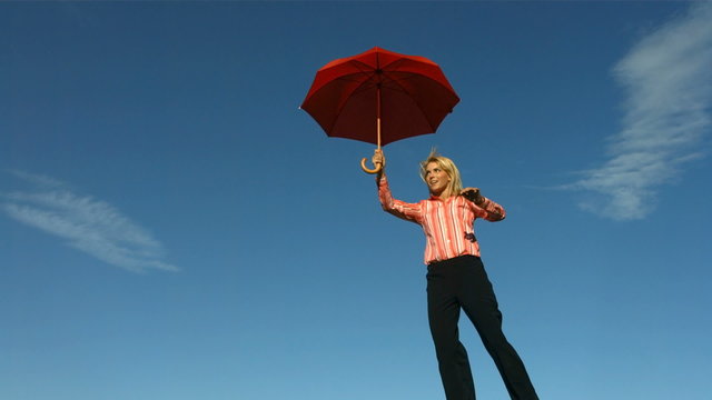 Happy woman flying with umbrella 