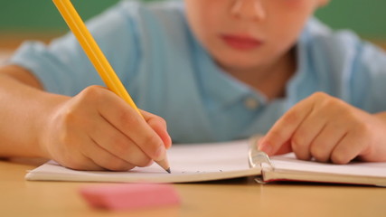 Child writing at school - Powered by Adobe