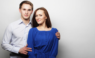 lovely happy couple hugging over grey background.