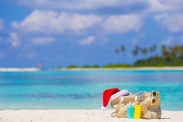 Fototapeta na wymiar Beach accessories with Santa Hat on white tropical beach