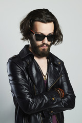 handsome bearded man in a leather jacket. Hipster in sunglasses