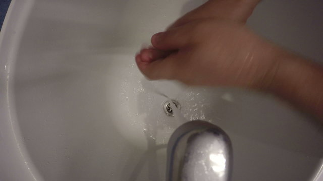 man wash hands soap under tap. Camera hang on tap handle. 4K