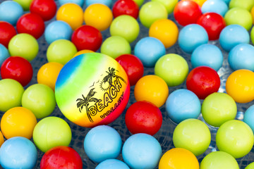 Fototapeta na wymiar Plastic volleyball swimming between many colorful plastic balls on a children pool