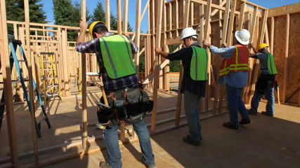 Group of construction workers staning up wall