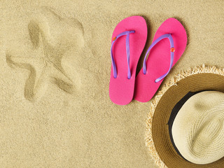 Fototapeta na wymiar Slippers and hat on sand