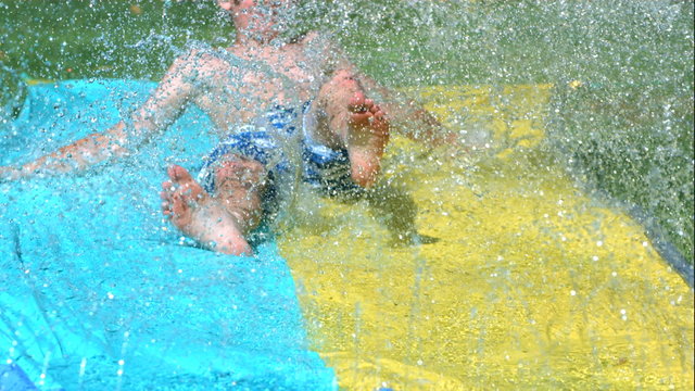 Young boy on water slide in slow motion