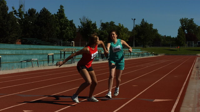 Athletes pass the baton in a track relay