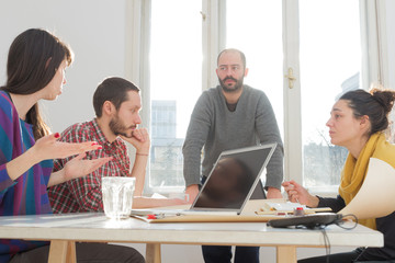 Young group of people/architects discussing business plans.
