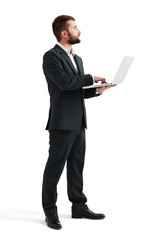 businessman holding laptop and looking up