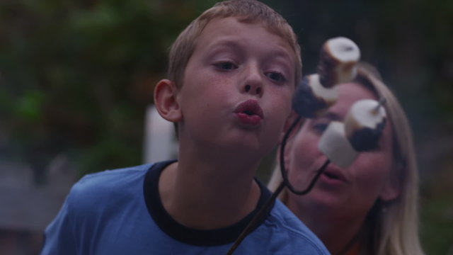 Closeup, roasting marshmallows by outdoor fire. 