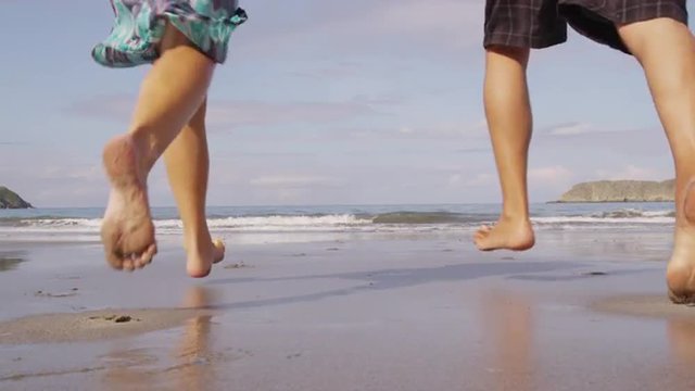 Couple running out to ocean, slow motion, Costa Rica