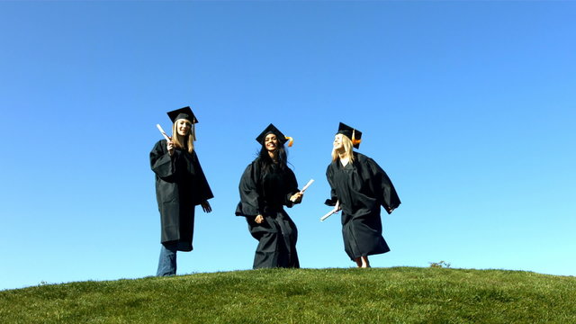 Three graduates jumping and celebrating