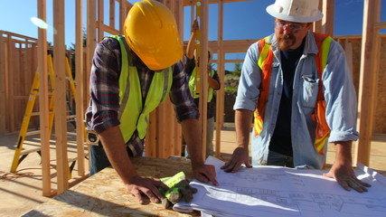 Construction workers looking over plans together