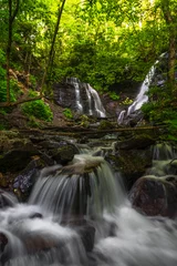 Tuinposter The flow of the water at Soco Falls cascades down the mountain and over the rocks on its way towards Cherokee, North Carolina in the Appalachian Mountains   © skiserge1