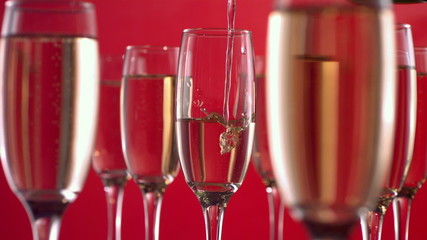 Pouring champagne on red background, slow motion - Powered by Adobe