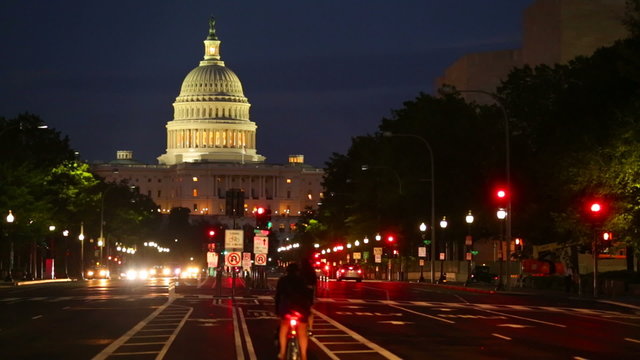 United States Capitol building night view from Pennsylvania Avenue with car lights