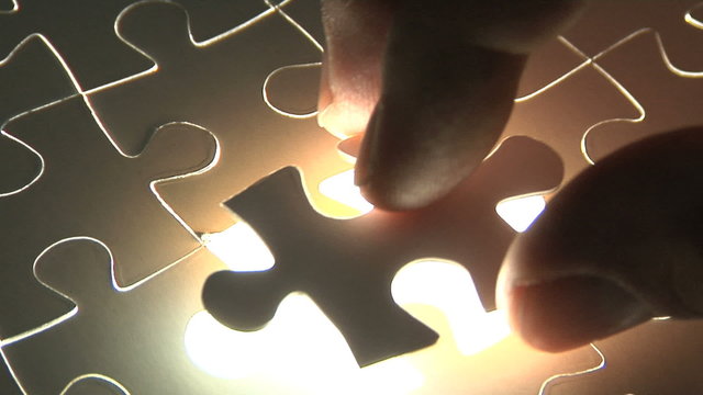 Hand places piece into puzzle