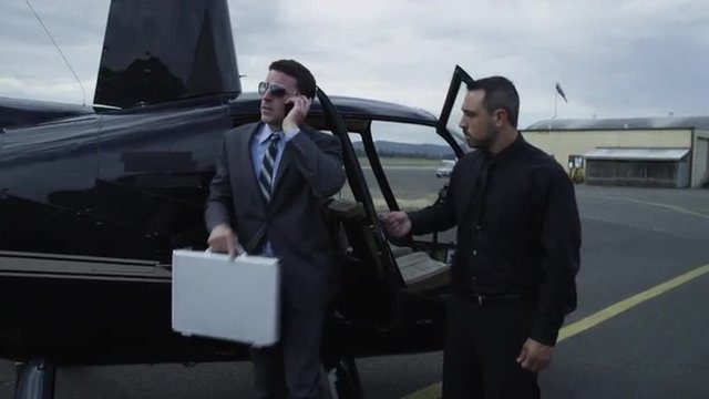 Businessman getting out of helicopter