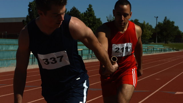 Athletes pass the baton in a track relay