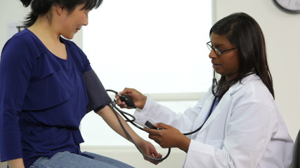 Doctor checking patient's blood pressure