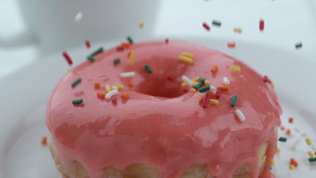 Sprinkles falling onto donut in slow motion
