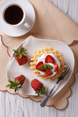 waffles with fresh strawberries and coffee closeup. vertical top view
