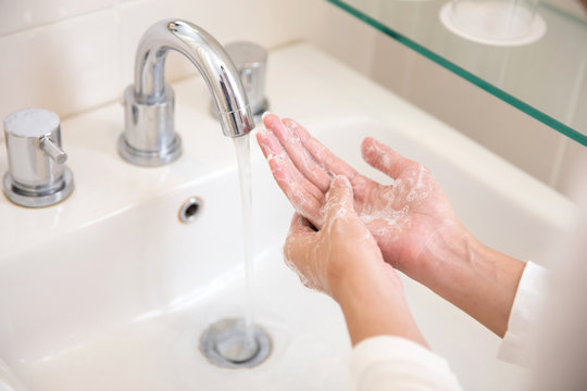 Washing hands with soap under running water, woman hands