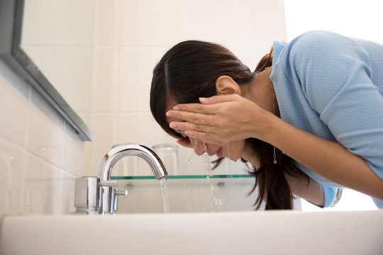 Asian Woman Washing Her Face On The Sink