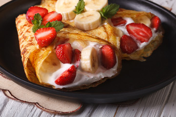 pancakes with fresh strawberries, bananas and cream close-up 
