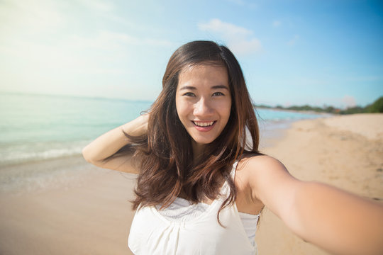 Happy young Asian woman take photos, smile to camera