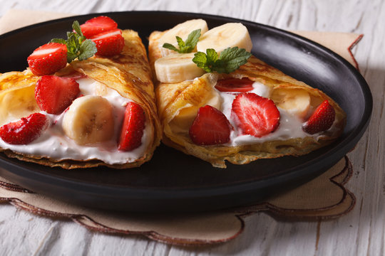 homemade pancakes with fresh strawberries, bananas and cream 