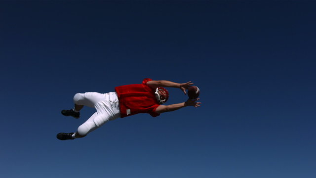 Football player catches ball, slow motion