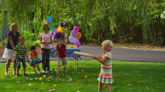 Girl hitting a pinata at party