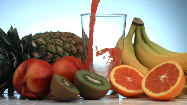 Fruit juice pouring into glass, slow motion