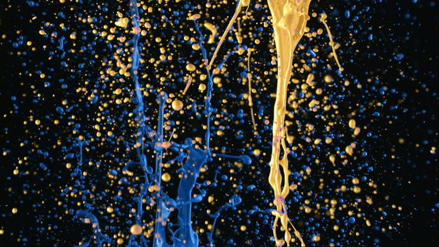 Yellow and blue paint splattering in slow motion