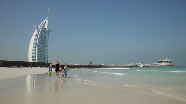 DUBAI, UNITED ARAB EMIRATES - Mother and children walk at Jumeirah beach (Model Released)