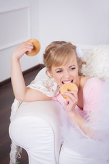 Beautiful woman sitting with a donut in his hand