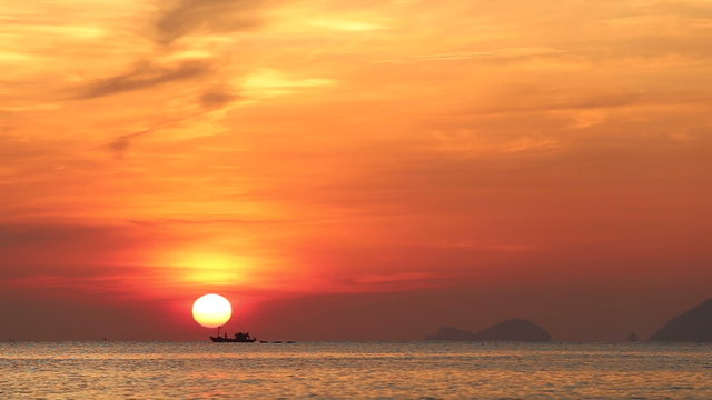 panorama of boat drifting at background of sun disk	