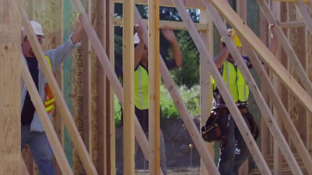 Group of construction workers staning up wall