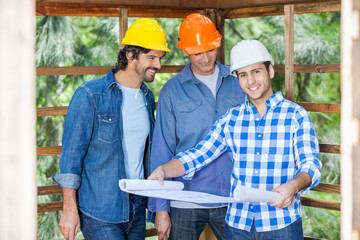 Fototapeta premium Happy Architect With Colleagues Analyzing Blueprint At Site