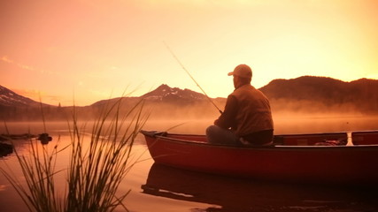 Man fishing in lake at sunrise - Powered by Adobe