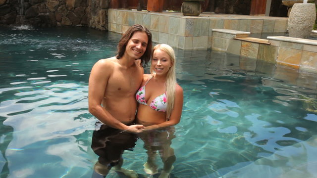 Portrait of couple at tropical resort pool