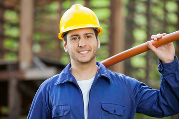 Happy Construction Worker Holding Pipe