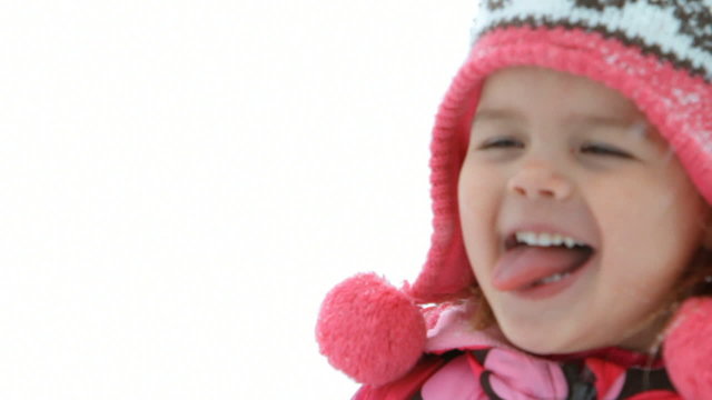 Young girl catching snowflakes on tongue